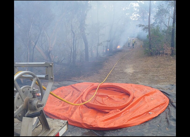 Enhanced bushfire management team hosing flames with Bouy Wall at Ku-ring-gai Chase National Park