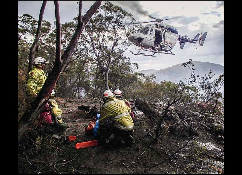 Remote Area Fire Team on a ridge near Martindale Creek, Bulga. A helicopter is hovering above the team.