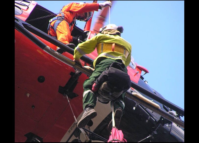 RAFT Remote Area Fire Team member winching out of helicopter 