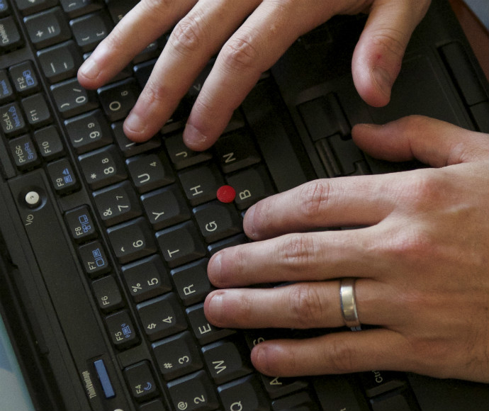 Two hands typing on a keyboard