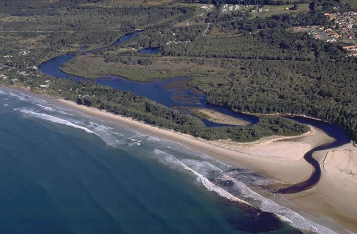 A view of Belongil Creek meeting the sea near Byron Bay with Belongil Beach in the foreground