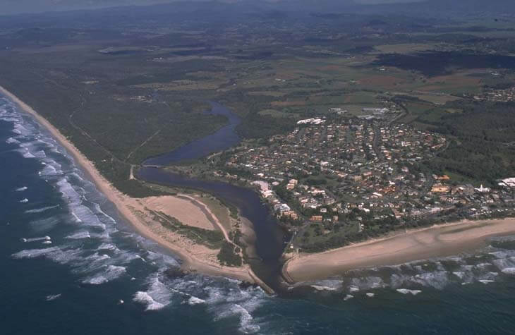 A view of Cudgen Creek meeting the sea next to the coastal town of Kingcliff and Kingscliff Beach in the foreground