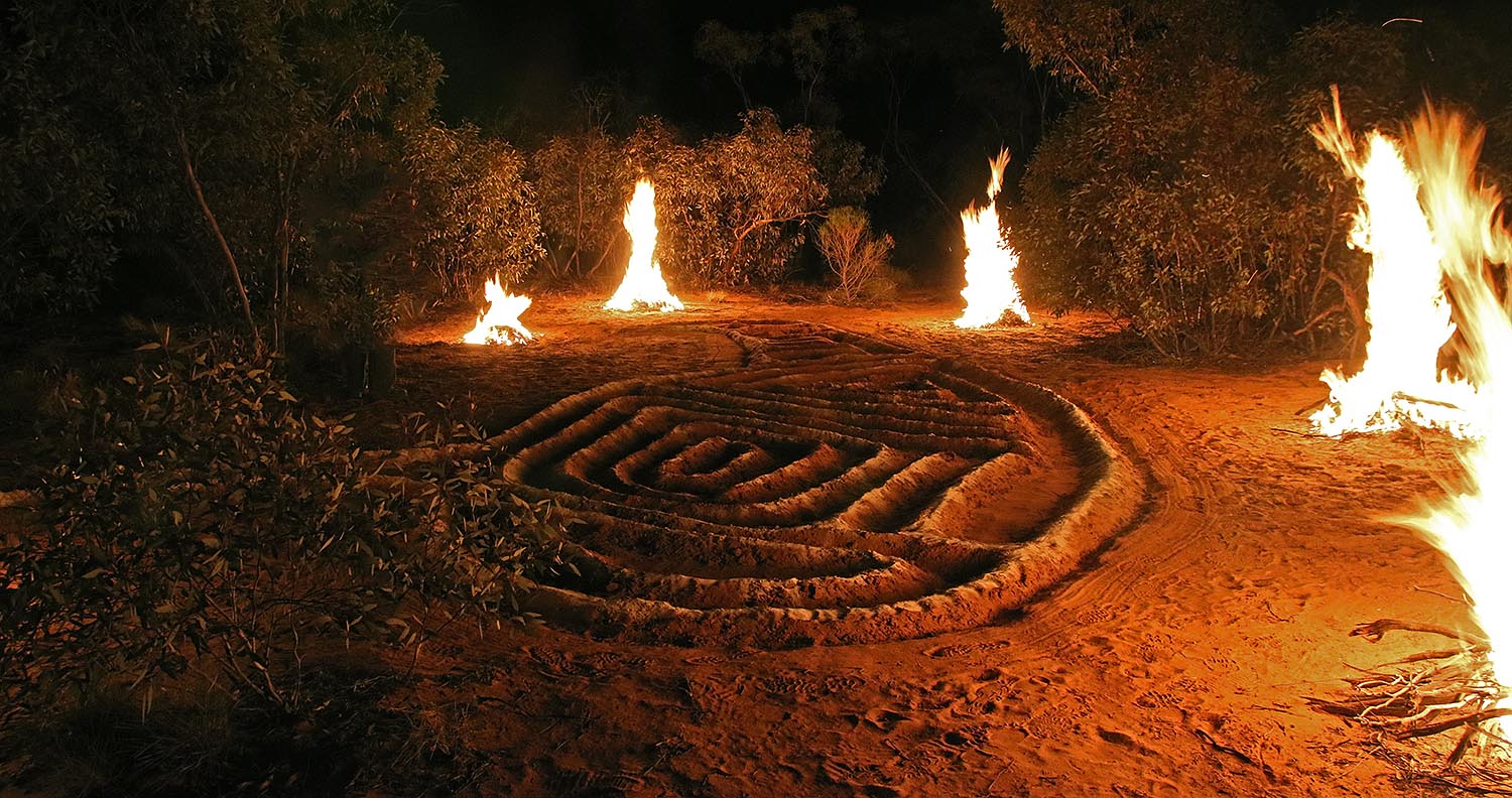 Malleefowl ground art on Country at night, with contained fires surrounding the art