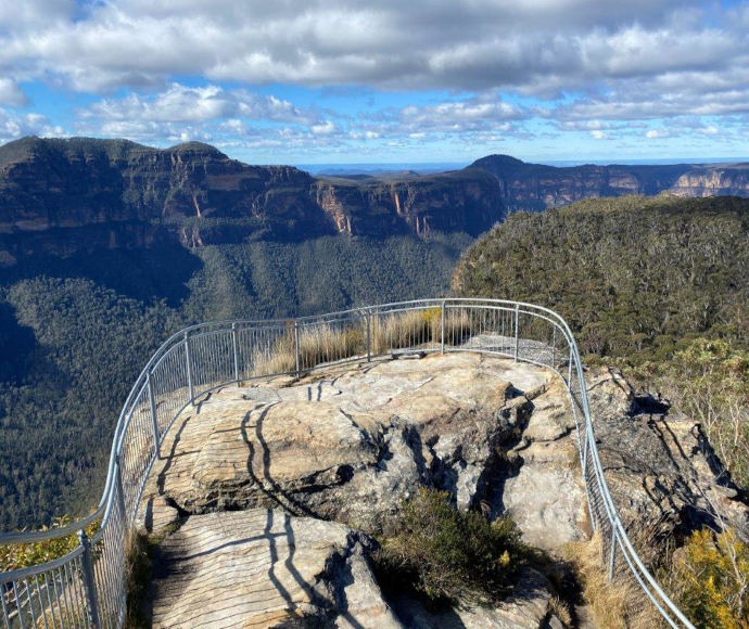 Rocky lookout over the valley with metal safety fence.