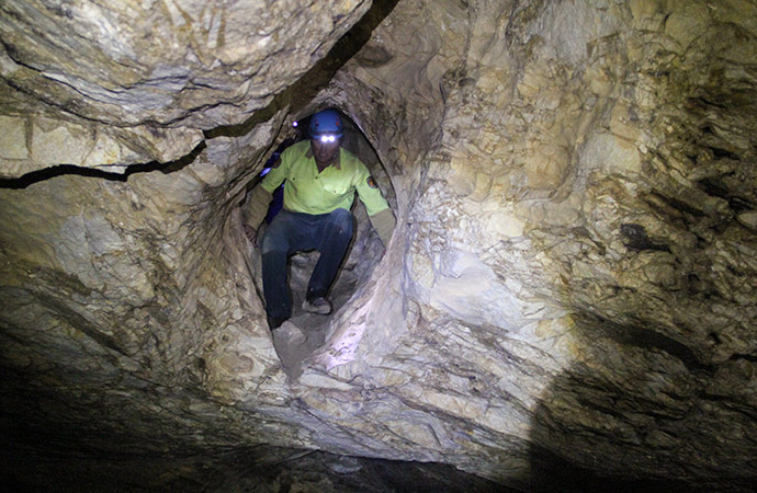 Caver with headlamp in Dennings Labyrinth, Wombeyan Karst Conservation Reserve