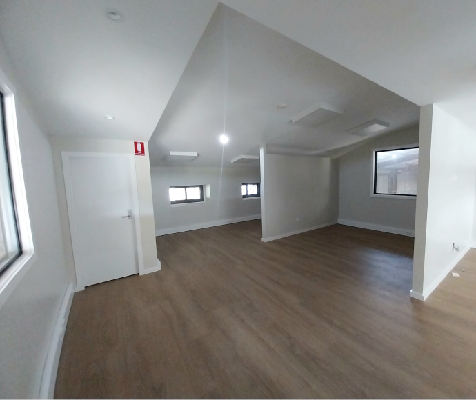 A white angular space with timber or laminate flooring