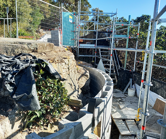 An image showing the new concrete blockwork wall around the outer eastern perimeter, which will be concealed behind a newly rebuilt sandstone wall made from salvaged sandstone from the site. The photo highlights the construction area and the materials used in the project.