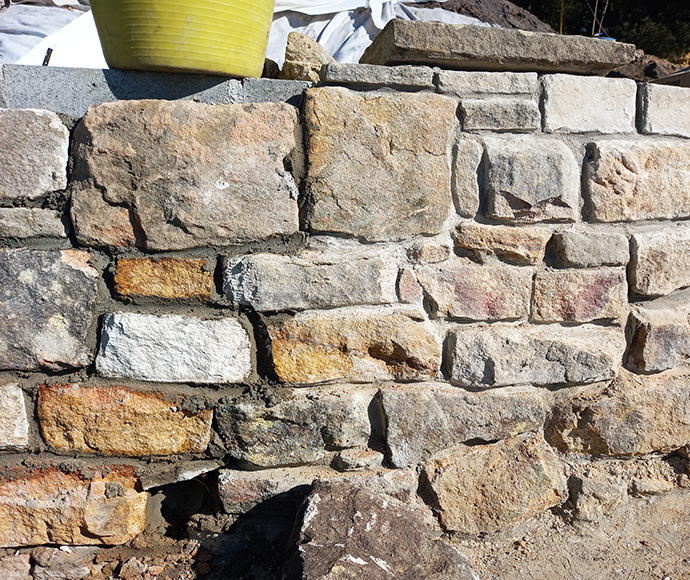 An image of the outer sandstone wall at West Head Lookout in Ku-ring-gai Chase National Park, highlighting the texture and color of the stone, showcasing the wall's integration into the natural environment.