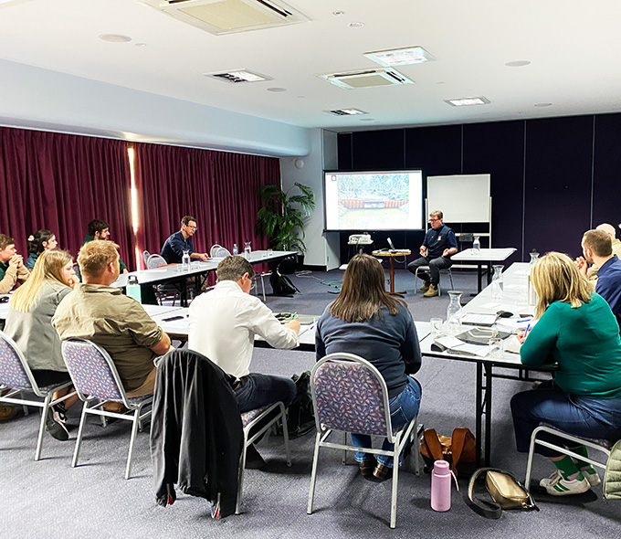 A group of people listening to a presentation with slides on screen