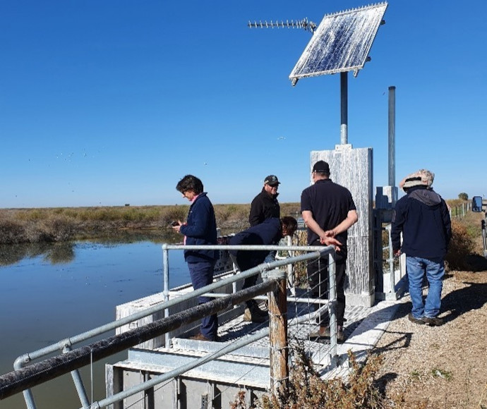 People standing on a river bank platform as part of a Gayini annual environmental water planning workshop with the Nari Nari