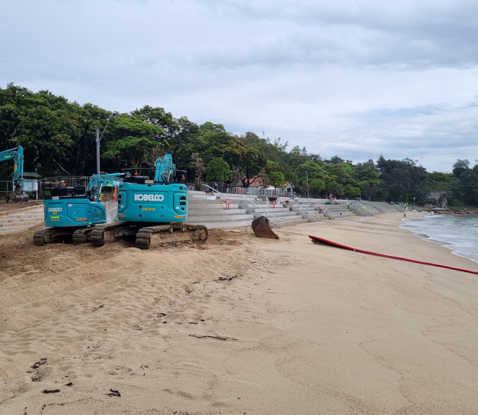 Construction of a new seawall built over a sandy beach. 