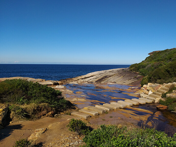 A path of stone pavers along a clifftop by the ocean