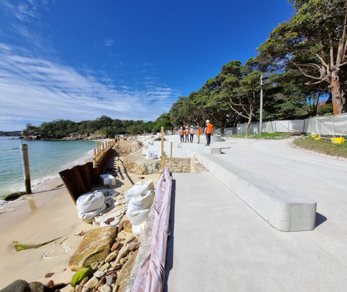 A smooth promenade in a small picturesque bay with workmen and construction around it