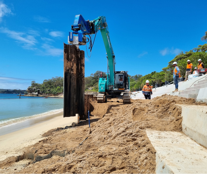 Machinery, earth and workmen on fresh-laid bleachers in a small picturesque bay