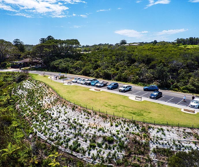 Completed landscaping at North Head, Sydney Harbour National Park, showing a newly paved car park area with marked parking spaces and surrounding native vegetation.